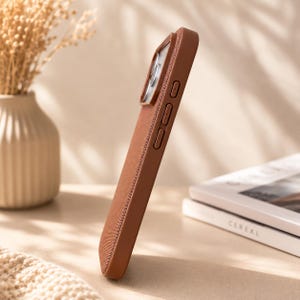May include: A solid brown smartphone case with a textured fabric finish on the back and sides. The case features a raised camera cutout, integrated side buttons for volume control, and a slim profile designed to fit a mobile device securely.