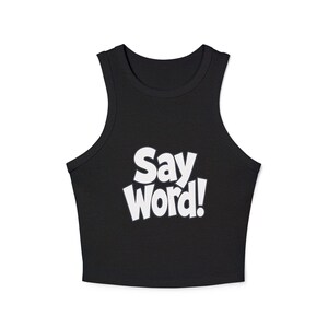 May include: A black sleeveless crop top featuring a high neckline and thick shoulder straps. The centre of the garment displays the text "Say Word!" printed in bold, white, sans-serif capital letters with a slight tilt and a playful font style.