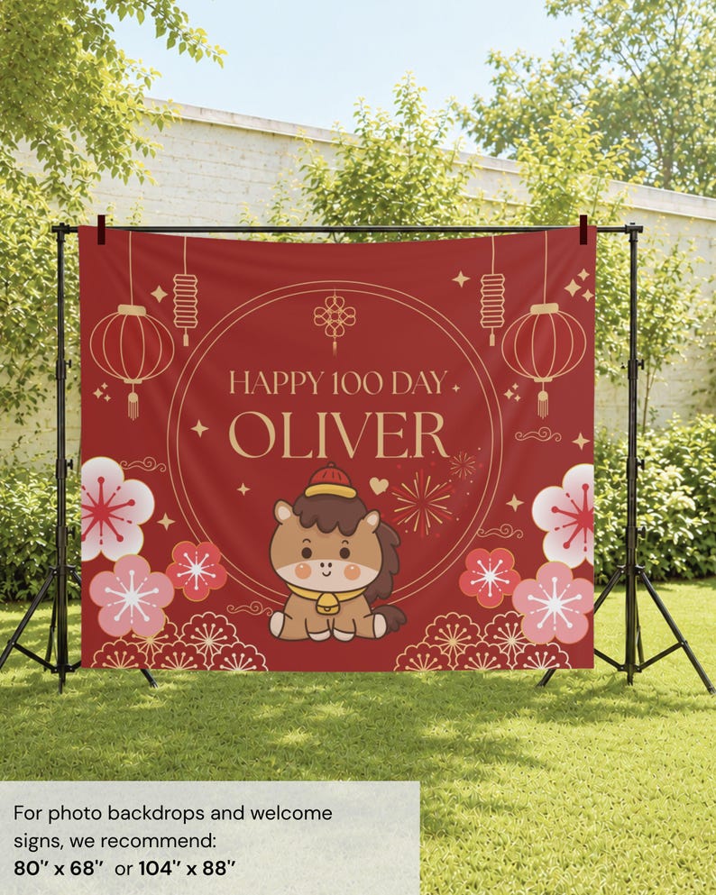 May include: A red rectangular backdrop featuring the text HAPPY 100 DAY OLIVER in gold lettering. The design includes a central cartoon horse, gold lanterns, and pink floral patterns. The backdrop is mounted on a black metal stand frame.