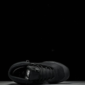 May include: Black hiking boot with a mesh upper and a lace-up closure. The boot has a padded collar and a durable rubber sole. The boot is designed for outdoor activities and features the brand name "TERREX".