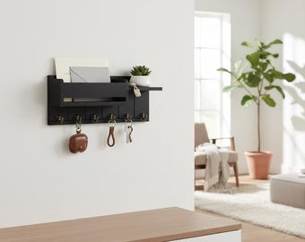 Wandgemonteerde houten organizer met moderne zwarte afwerking en gouden haken voor de hal en woonkamer.