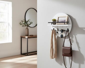 Houten wandorganizer met rond ontwerp, witte afwerking en zwarte metalen haken. Een ideale opbergoplossing voor de hal.