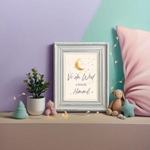Könnte beinhalten: Ein gerahmter Druck mit dem Text "Vo da Wöd a Stückl Himmel" und einem Mond und Sternen-Design. Eine kleine Topfpflanze, ein Weihnachtsbaum aus Filz und ein rosa Teddybär stehen auf einem Regal. Ein Stoffhase und ein Stern sind ebenfalls vorhanden.