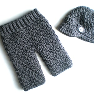 May include: Gray crocheted baby pants and hat set. The hat has a button on top.