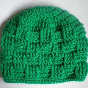 May include: A green crocheted beanie hat with a woven pattern.