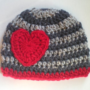 May include: Gray and white striped crocheted beanie with a red crocheted heart on the front.