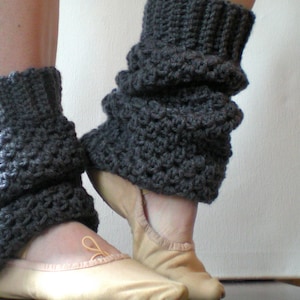 Puede incluir: Calentadores de piernas de crochet gris con textura acanalada, usados sobre zapatillas de ballet.
