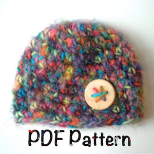 Puede incluir: Un gorro de crochet colorido con un botón de madera. El gorro está hecho con una variedad de colores, incluyendo rosa, azul, verde, amarillo y morado. El botón es un botón redondo simple con un diseño de punto de cruz. El gorro es un patrón PDF.