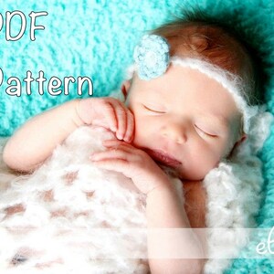 Op de afbeelding: Een slapende babymeisje met een witte gehaakte deken en een blauw bloemenhoofdband. De baby ligt op een turquoise, pluche deken. De tekst "PDF Pattern" staat in de linkerbovenhoek van de afbeelding. De tekst "elkay" staat in de rechterbenedenhoek van de afbeelding.