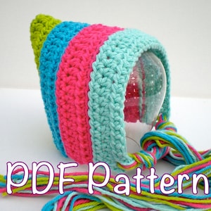 May include: A colourful crocheted hat with a pointed top and long tassels. The hat is striped in pink, blue and green.