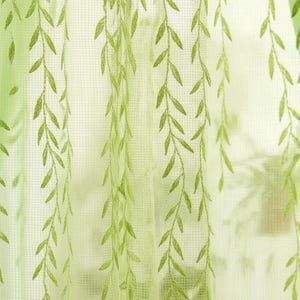 Könnte beinhalten: Transparenter grüner Vorhang mit gesticktem Trauerweidenblatt-Design. Der Vorhang hat einen hellgrünen Hintergrund mit einem Gittermuster. Die gestickten Blätter sind in einem dunkleren Grünton gehalten.