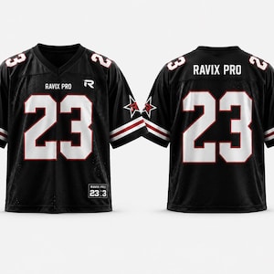 Pode incluir: Uma camisola preta de manga curta com o número 23 em fonte branca grande com contornos vermelhos na frente e nas costas. O texto RAVIX PRO aparece no peito e na parte superior das costas. Logótipos de estrelas nas mangas e etiqueta RAVIX PRO 23:3.