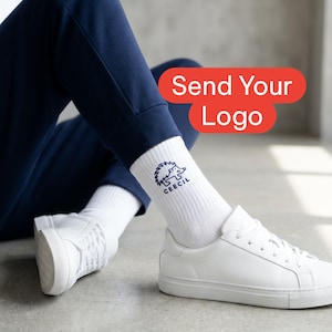 May include: White crew socks featuring a dark blue embroidered hedgehog graphic and the text CEECIL. The socks are worn with white sneakers and navy blue pants. A red rectangular graphic overlay displays the text Send Your Logo.