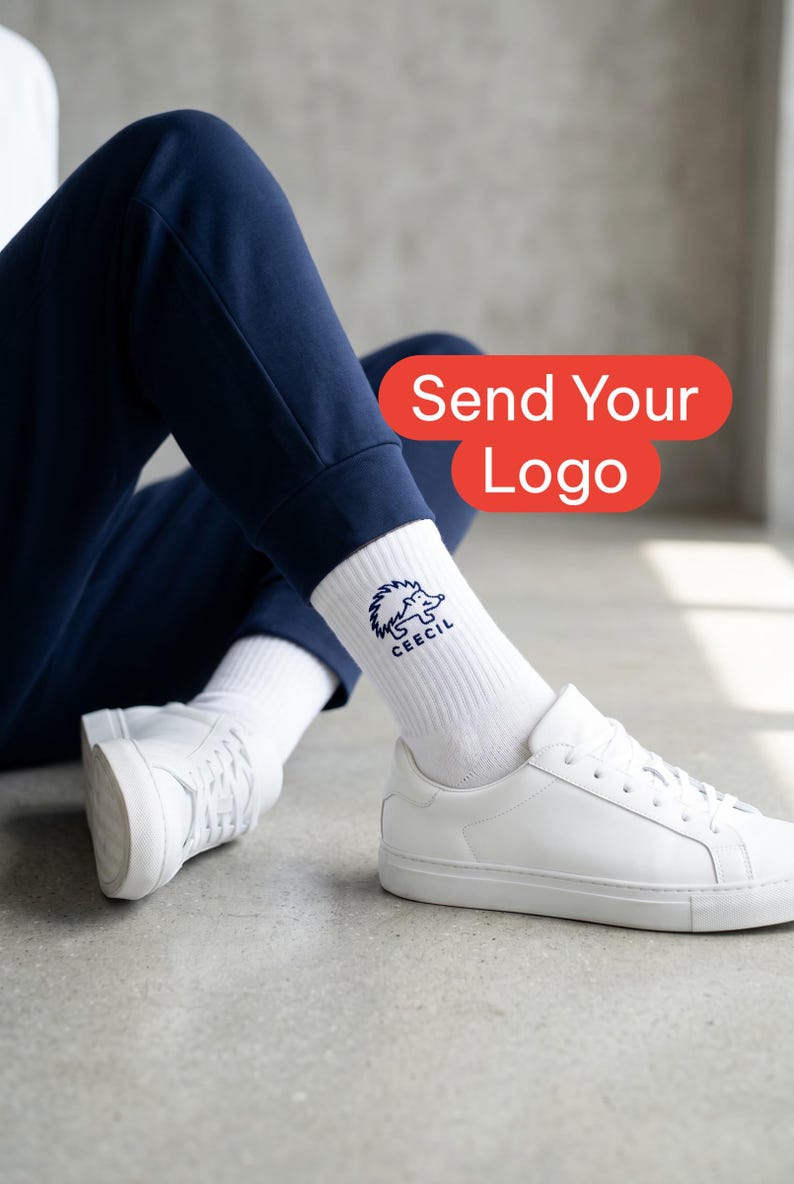 May include: White crew socks featuring a dark blue embroidered hedgehog graphic and the text CEECIL. The socks are worn with white sneakers and navy blue pants. A red rectangular graphic overlay displays the text Send Your Logo.