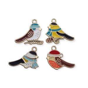 May include: Four gold-tone metal charms featuring cartoon birds wearing winter hats and scarves. The birds are in various colors, including red, yellow, blue, and white.