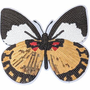 May include: A gold and black sequined butterfly applique with red accents. The butterfly has white wings with black edges.