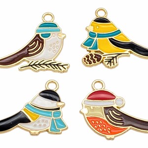 May include: Four gold-tone metal charms shaped like birds with colorful enamel paint. Each bird has a different color scheme and design. The birds are wearing hats and scarves.