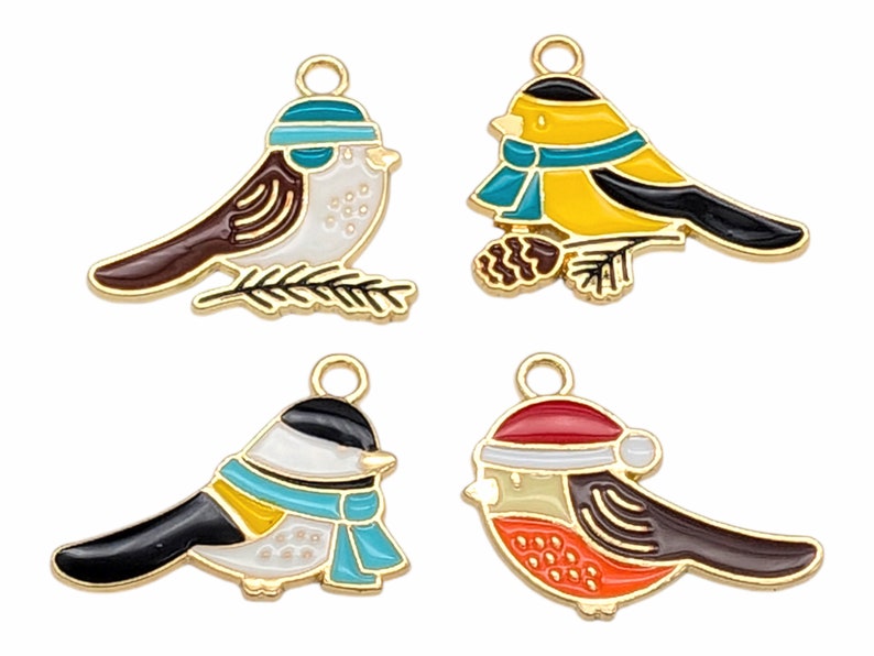 May include: Four gold-tone metal charms shaped like birds with colorful enamel paint. Each bird has a different color scheme and design. The birds are wearing hats and scarves.