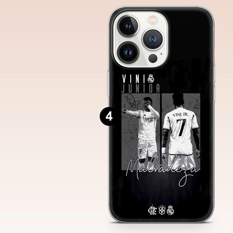 May include: A black smartphone case featuring a graphic design of soccer player Vini Jr. The case displays two monochrome images of the player, the text VINI JUNIOR, the word Malvadeza in script, and three small sports club logos at the bottom.