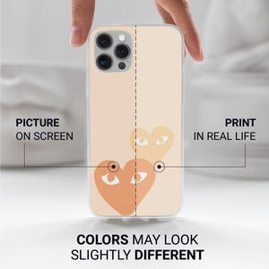 Może przedstawiać: Przezroczyste etui na telefon z brzoskwiniowym wzorem dw&oacute;ch figur w kształcie serca z oczami. Widoczne są teksty "PICTURE ON SCREEN" i "PRINT IN REAL LIFE". Obecny jest r&oacute;wnież tekst "COLORS MAY LOOK SLIGHTLY DIFFERENT".