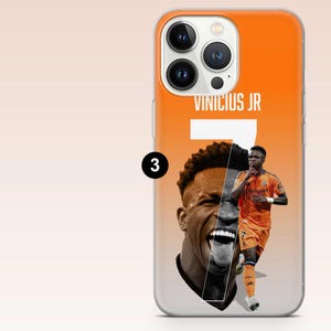 May include: An orange and white smartphone case featuring a large graphic of soccer player Vinicius Jr. with the text VINICIUS JR and the number 7 printed in white. The design includes a close-up portrait and a full-body action shot of the player.