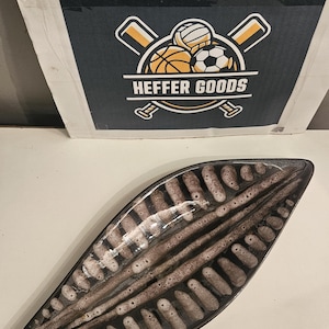 May include: A leaf-shaped decorative tray with a glossy finish, featuring a dark brown and black speckled pattern that mimics natural textures. The tray has a pointed, elongated form with a smooth, curved surface and a dark, solid border.