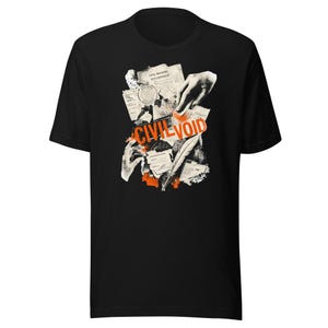 Könnte beinhalten: Ein schwarzes Kurzarm-T-Shirt mit einem Grafikdruck aus verstreuten alten Dokumenten, einer Feder und Händen. Der Text "CIVIL VOID" ist in fetten orangefarbenen Buchstaben in der Mitte des Designs gedruckt, das auch orangefarbene Akzente enthält.