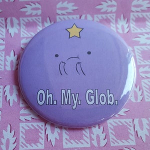 May include: Purple round button featuring a cartoon character with a star on its head and the text "Oh. My. Glob."