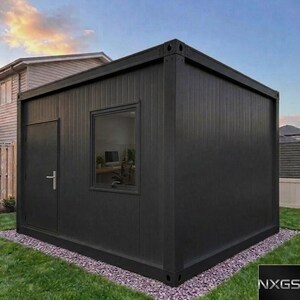 May include: A black, modern, rectangular structure with a door, window, and a flat roof. The structure is set on a bed of small stones and surrounded by green grass. The window reveals an interior with a desk and computer.