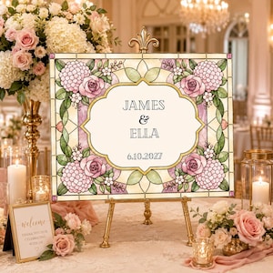 K&ouml;nnte beinhalten: Ein rechteckiges Hochzeitsschild mit einem Rand im Buntglas-Stil, verziert mit rosa Rosen, violetten Hortensien und gr&uuml;nen Bl&auml;ttern. Das mittlere Feld zeigt den Text JAMES & ELLA und das Datum 6.10.2027 in einem Rahmen auf einer goldenen Staffelei.