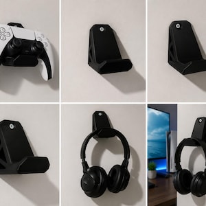 May include: Black wall-mounted holders for gaming accessories. One holder supports a white and black game controller. Other holders display black headphones. The holders are mounted on a white wall.