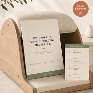 May include: A light wood and cream-colored Pilates spine corrector barrel with a reference book titled The Barrel & Spine Corrector Reference and a small green card labeled Barrel Quick Reference featuring set-up and training instructions.