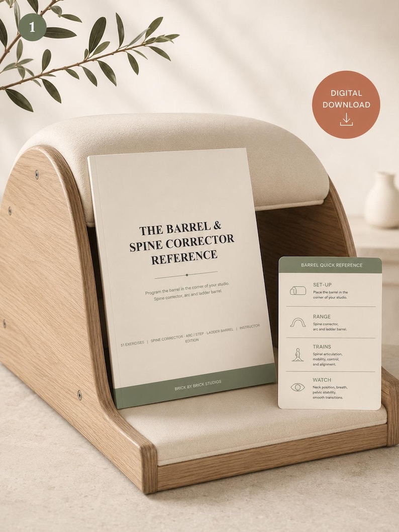 May include: A light wood and cream-colored Pilates spine corrector barrel with a reference book titled The Barrel & Spine Corrector Reference and a small green card labeled Barrel Quick Reference featuring set-up and training instructions.