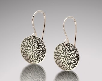 Pendientes de plata de ley con diseño de copo de nieve grabado.