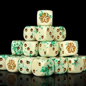 May include: A pyramid stack of off-white six-sided dice with green speckles and gold-colored pips. Several dice feature a gold-colored biohazard symbol with three skulls in the center, replacing the standard six-pip face on those specific dice.