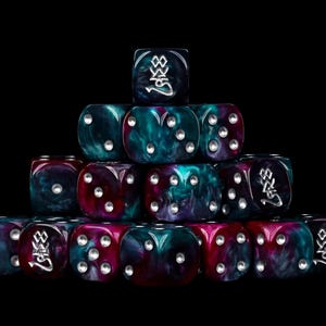 Può includere: Una piramide di dadi a più facce caratterizzata da una miscela vorticosa di colori blu ottanio profondo, magenta e viola. Ogni dado presenta punti color argento e un simbolo argentato unico sulla faccia superiore, su sfondo nero.