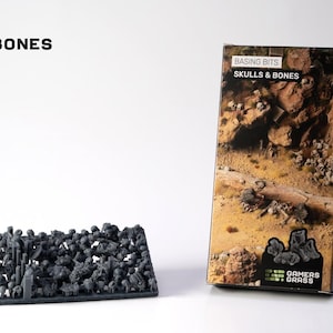 May include: A product shot features a tray of miniature skulls and bones next to a product box. The box displays a desert scene with skulls and bones. The text "BASING BITS" and "SKULLS & BONES" is visible.