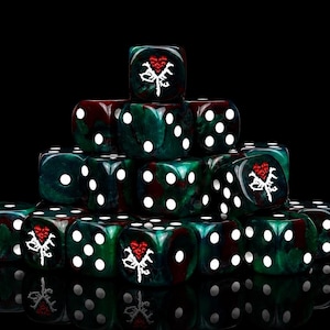 May include: A pyramid-shaped stack of dark green and maroon marbled dice with white pips. Several dice feature a custom white graphic of a stylized heart with a dagger or thorn motif, replacing the standard six-sided pip on one face of each die.