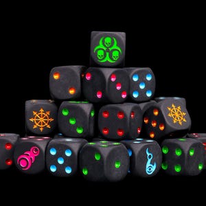 May include: A pyramid-shaped stack of matte black six-sided dice. Each die features vibrant, neon-coloured pips and symbols, including a green biohazard sign, orange star-like emblems, pink circular patterns, and various blue, red, and green dots.