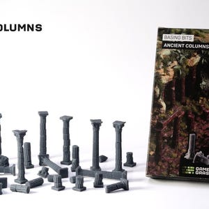 May include: A selection of grey plastic ancient columns, some upright and some fallen, of different heights and designs. The product is labelled "Basing Bits Ancient Columns" and is packaged in a box with a forest scene.