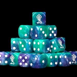 May include: A pyramid stack of six-sided dice featuring a marbled teal and purple resin finish. Each die has white pips and a custom white graphic symbol of an eye above a stylized character on the six-face. The dice are arranged in a triangular formation.
