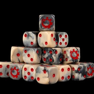Puede incluir: Una pila piramidal de dados de seis caras con un acabado jaspeado en crema y gris con puntos rojos brillantes. Algunas caras muestran un icono de engranaje rojo en lugar de los puntos numéricos estándar. Los dados están dispuestos en una formación triangular sobre un fondo negro.