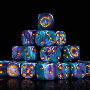 May include: A pyramid-shaped stack of multi-sided dice featuring a swirling purple and teal marbled pattern. Each die has recessed circular pips and a circular dragon emblem on one face, all filled with a bright, metallic gold-colored paint.