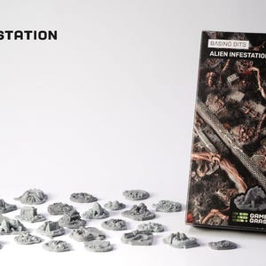 Puede incluir: Una caja de producto y piezas de terreno en miniatura para juegos de mesa. La caja dice "Basing Bits Alien Infestation". Las piezas de terreno son grises y están dispersas sobre una superficie blanca. La caja está llena de elementos marrones y grises.