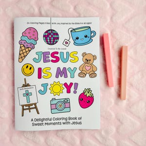 May include: A coloring book with the text "JESUS IS MY JOY!" and illustrations of an ice cream cone, disco ball, teacup, teddy bear, smiley face, camera, strawberry, and cross. Two pink highlighters are next to the book.