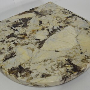 May include: A white, brown, and black granite countertop with a rounded edge.