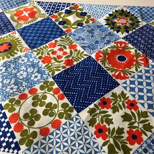 May include: A patchwork fabric with a variety of geometric and floral patterns in shades of blue, orange, green, and white. The fabric is labeled "Waverly Fabrics" and "Quilt-In".