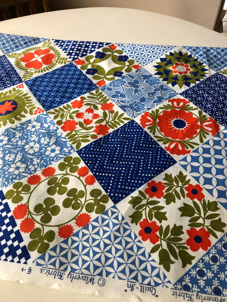 May include: A patchwork fabric with a variety of geometric and floral patterns in shades of blue, orange, green, and white. The fabric is labeled "Waverly Fabrics" and "Quilt-In".