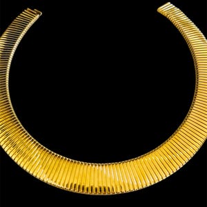 May include: A gold-toned, ribbed, metal choker necklace.