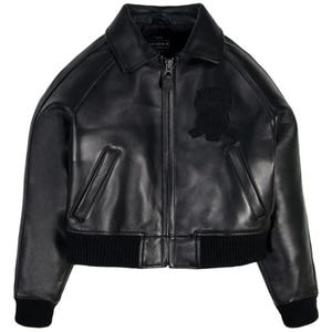 May include: A black leather bomber jacket featuring a classic collar, a full-length front zipper closure, and two slanted welt pockets. The jacket includes black ribbed knit cuffs and a matching ribbed hem, with a tonal embroidered patch on the chest.